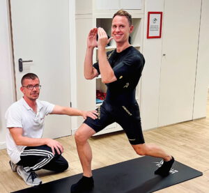 Trainer zeigt Kunde Übung beim EM-Training