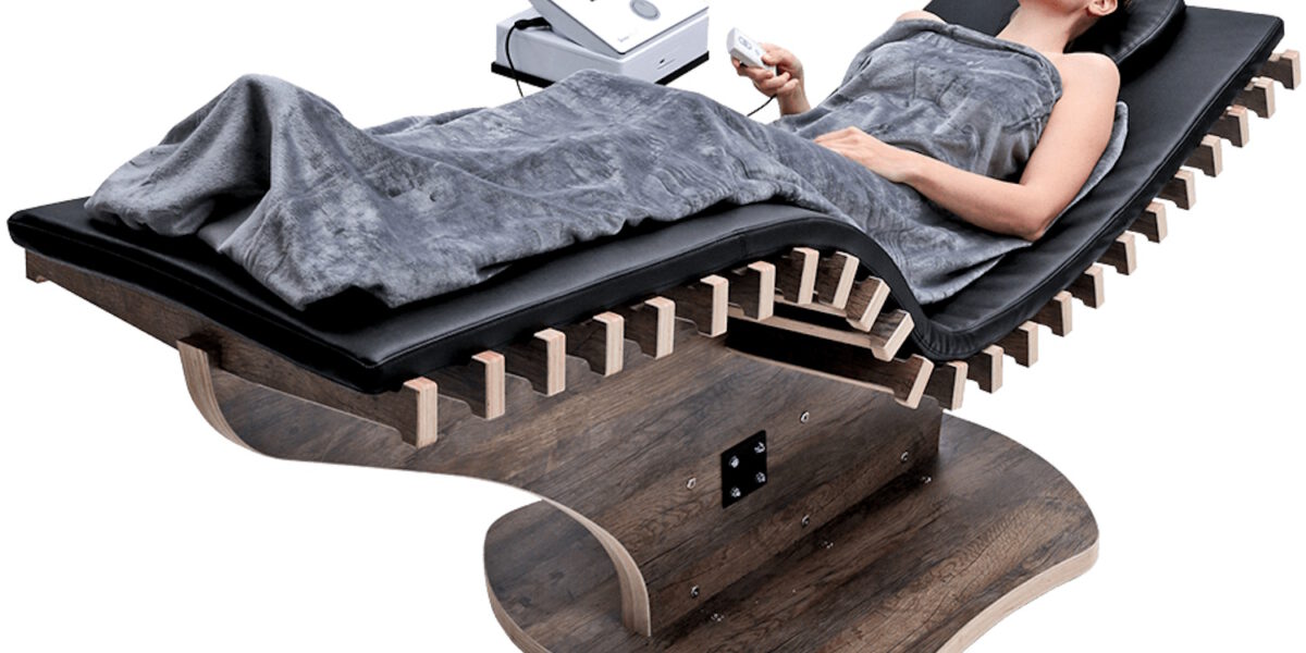 Person liegt auf einer EMS-Rückenliege in Hamburg zur Stärkung der Rückenmuskulatur